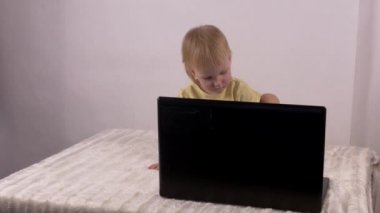 Küçük beyaz kız oynar ve bilgisayar laptop, duygular, 4 k ile çalış
