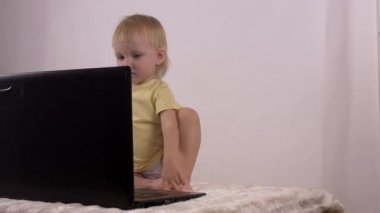 Küçük beyaz kız oynar ve bilgisayar laptop, duygular, 4 k ile çalış