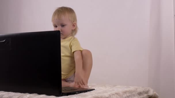 Pouco caucasiano menina joga e brinca com computador portátil, emoções, 4K — Vídeo de Stock