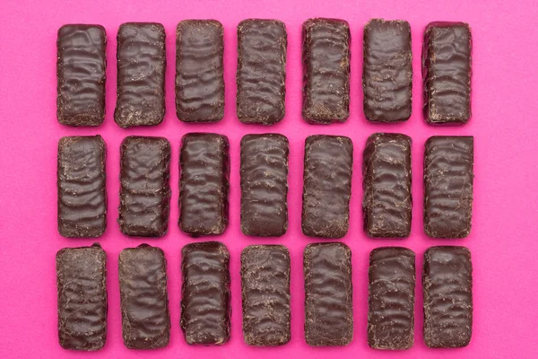 Un sacco di cioccolatini su uno sfondo rosa, lo sfondo di cioccolatini, caramelle — Foto Stock