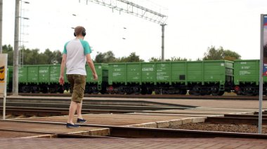 Genç bir adam Kulaklığımda demiryolu parça geçerek ve müzik dinliyor, yaklaşan tren duymuyor