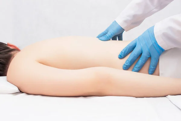 The doctor performs a massage and examination of the patient who has a back ache, medicine, copy space — ストック写真