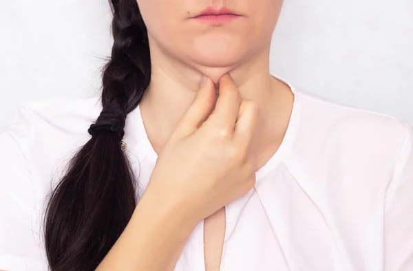 Caucasian beautiful girl pulls her hand off a double fat chin, a problem with a hanging chin, white background — Stock Photo, Image