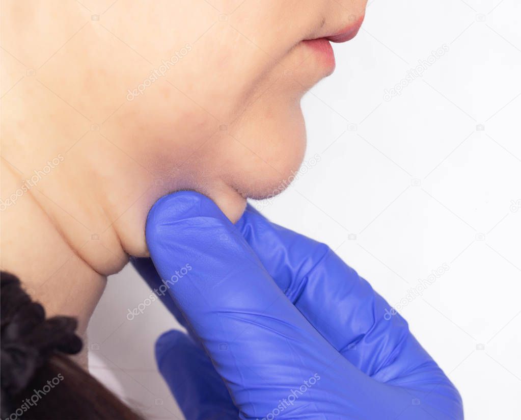 Doctor plastic surgeon examines a double patient selection before surgery, close-up
