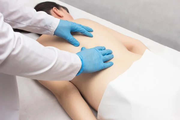 Doctor makes therapeutic massage to a patient who has problems and back pain, medical — Stock Image Doctor makes therapeutic massage to a patient who has problems and back pain, medical Royalty Free Stock Images