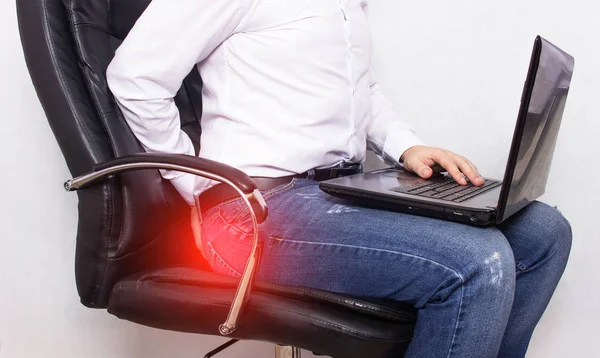 Un hombre con una camisa blanca se aferra al ano el concepto de dolor en el recto, hemorroides, inflamación — Foto de Stock