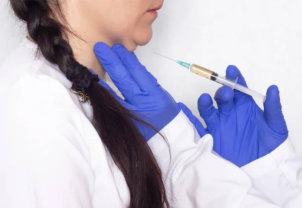 The doctor makes plasma-lifting injections in the double chin of the girl, plasma therapy in cosmetology