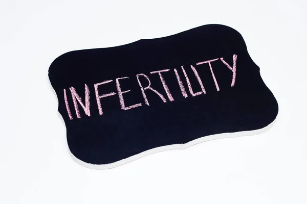 Il piatto su cui è scritta con gesso la parola infertilità, infertilità maschile e femminile, sfondo bianco — Foto Stock