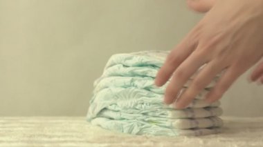 Anne bebek bezi tablosundan bir yığın beyaz bir arka plan üzerinde kopya alanı, yavaş hareket alır.