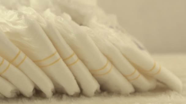 Купа дитячих підгузників на білому тлі, впритул, фон, серветка — стокове відео