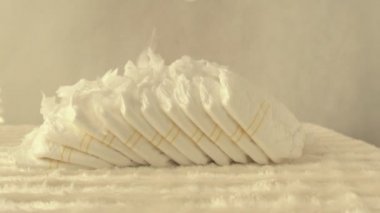 Bebek bezi kavramı saflık, rahatlık ve konfor, ağır çekim, kopya alanı üzerinde beyaz tüyler düşmek