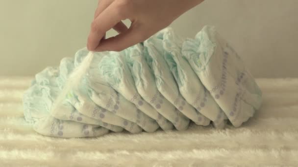 母亲拿着白色的羽毛在婴儿尿布上, 舒适和轻盈的概念, 慢动作 — 图库视频影像
