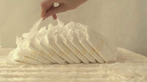母亲拿着白色的羽毛在婴儿尿布, 轻盈舒适的概念, 特写, 慢莫, 背景 — 图库视频影像