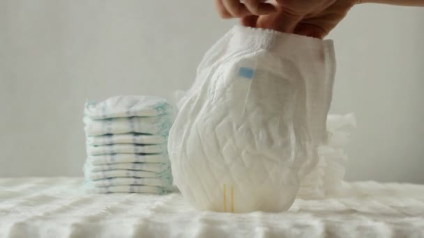 Mãe prepara fraldas para bebês na forma de calcinha para o bebê, fundo branco — Vídeo de Stock