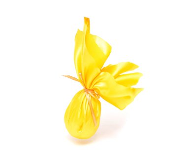 Yakın çekim, mevcut sarı Paskalya yortusu yumurta beyaz arka plan, ayrı tut, Paskalya tatili hediye kavramı, sarı hediye bezle sarılmış