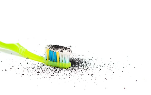 Cepillo de dientes con pasta de dientes con la adición de carbón activado y carbón Babmuk sobre un fondo blanco, para el tratamiento de encías de dientes y blanqueamiento, primer plano, aislar — Foto de Stock