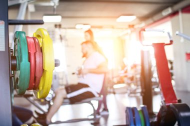 Bir adam bir eğitmen gözetiminde modern bir spor salonu simülatörde uygulamalar, bir gün batımı pencereden kopya alanı, parlıyor eğitmen