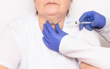 Bir doktor kırışıklıkları ve çift çene, yüz ve cilt gençleştirme, liposuction, serum kurtulmak için bir çift çene bir kadına ozon tedavisi ve mezoterapi enjeksiyonları yapar