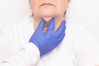 A plastic surgeon examines an aged caucasian woman to tighten and get rid of wrinkles and double chins, white background, cosmetologist clipart