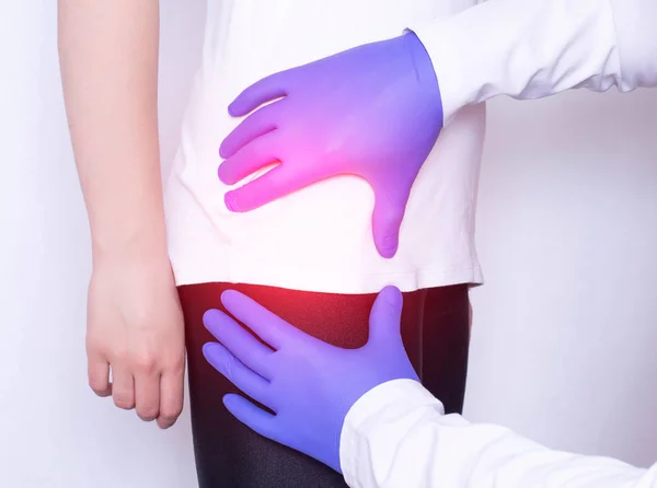 Girl on consultation with a doctor with a sick hip joint, synovitis and bursitis in the thigh, inflammation, osteoarthritis — Stock Image Girl on consultation with a doctor with a sick hip joint, synovitis and bursitis in the thigh, inflammation, osteoarthritis Royalty Free Stock Images