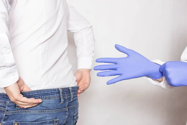 Médico urólogo pone un guante médico en el brazo para examinar la próstata del paciente, masaje de próstata, drenaje linfático — Foto de Stock