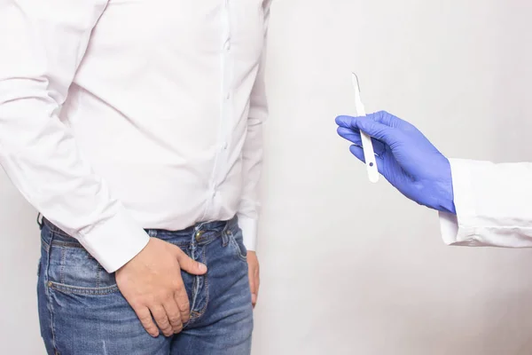 Un medico tiene un bisturi chirurgico sullo sfondo di un uomo il cui concetto di cancro alla prostata di chirurgia della prostata utilizzando una prostatectomia — Foto Stock