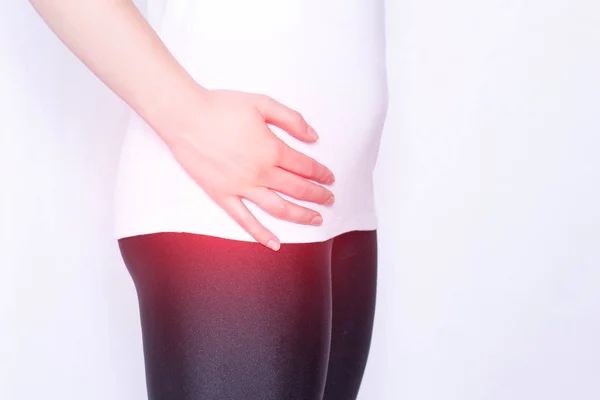 The girl holds on to the hip joint in which pain and inflammation, arthrosis and arthritis in the thigh, ankylosing spondylitis, copy space, medical — Stock Photo, Image