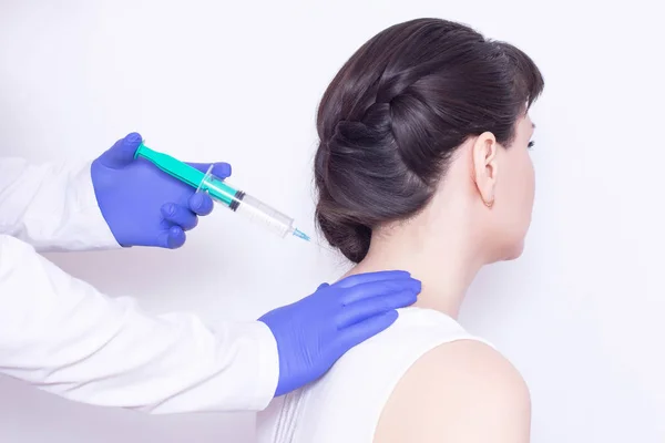The doctor makes an injection of chondroprotector and anesthetic in the cervical vertebrae of the girl to eliminate pain and stiffness, inflammation, close-up — Stock Image The doctor makes an injection of chondroprotector and anesthetic in the cervical vertebrae of the girl to eliminate pain and stiffness, inflammation, close-up Stock Image