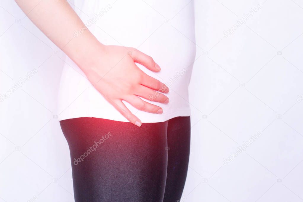 The girl holds on to the hip joint in which pain and inflammation, arthrosis and arthritis in the thigh, ankylosing spondylitis, copy space, medical