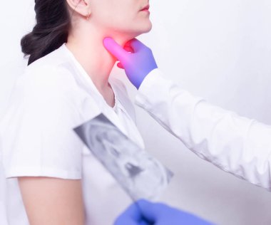 Uzman bir doktor iltihap ve şişlik varlığı için palpe tarafından bir kız boğaz ağrısı tanısı, boğaz ağrısı ve boğaz bademcik iltihabı
