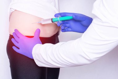 Doktor kızın kalça ekleminde anestezi ile hyaluronik asit ve kondroprotektör enjeksiyonu yapar, artrit tedavisi, tıbbi, osteoartrit
