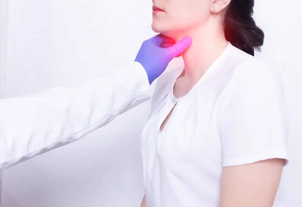 Um médico especialista diagnostica e examina a dor de garganta de uma menina, a presença de inflamação e inchaço, faringite e dor de garganta, doenças — Fotografia de Stock