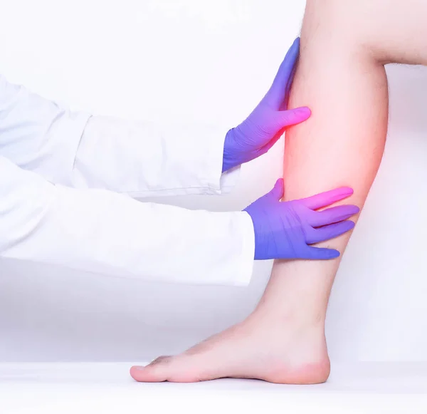 Cerrah, bir adamın bacağındaki hasarlı buzağı ligamentlerin tıbbi muayenesini yürütmektedir, sprains, Medikal, mikro kırıklar — Stok fotoğraf