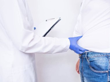 Doktor beslenme uzmanı, aşırı kilolu ve sağlıksız beslenme, fiziksel aktivite ile erkek bir hastanın test sonuçlarının fizik muayene ve değerlendirilmesi yapar.