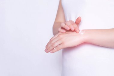 The girl rubs the healing ointment into the wrist joint against pain and inflammation in the joint, White background, copy space, stiffness clipart
