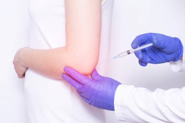 Doktor, dirsek eklemi, yakın çekim, kortikosteroid olan genç bir kıza kondroprotektör ve ozon tedavisi nin ablukasını enjekte ediyor.