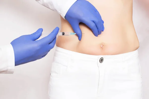 Doctor cosmetologist makes Botox injections and rejuvenation in the stomach of a girl. Smoothing wrinkles and wrinkles on the abdomen with the help of hyaluronic acid rejuvenation injections — Stock Photo, Image