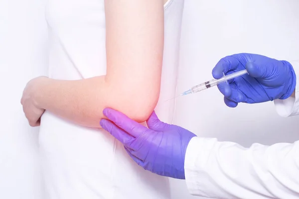 El médico inyecta bloqueo de condroprotector y ozonoterapia a una niña en una articulación dolorida del codo, primer plano, corticosteroide —  Fotos de Stock
