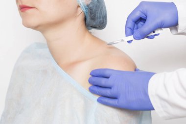 Doktor cerrah omuz eklemi cerrahi kız kavramının omzunun arka plan karşı bir neşter tutar ve yapay bir eklem, artroplasti yerine