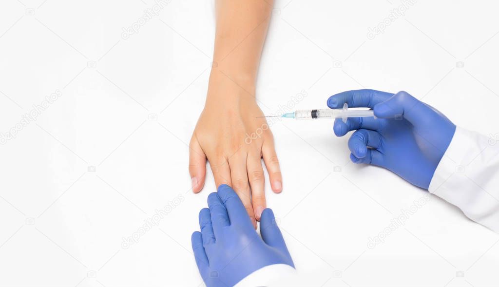 Doctor makes sclerotherapy injection into the arm of the girls patient for the disappearance of swollen veins, white background, copy space, treatment