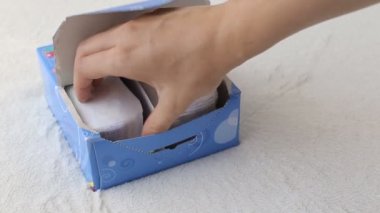 kız günlük sıhhi pedleri ile bir kutu açar ve bir alır, yakın çekim, sıhhi peçete