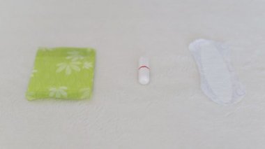 Kız adet için bir yastık seçer, kadın pedleri, sıhhi tamponlar, günlük ped