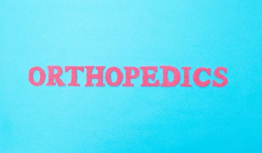 Mavi arka plan üzerinde kırmızı harflerle yazılmış ortopedi yazıt. Bu,