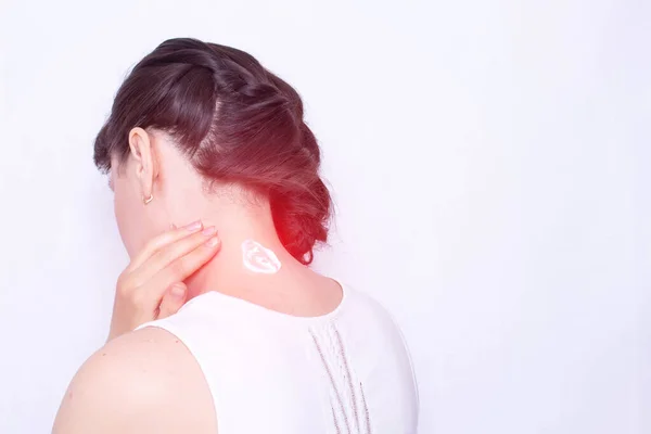 The girl smears her neck with a healing cream to relieve muscle tension and pain. Treatment of cervical spinal diseases, copy space — Stock Image The girl smears her neck with a healing cream to relieve muscle tension and pain. Treatment of cervical spinal diseases, copy space Stock Photo
