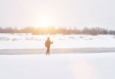 İnsan kışın nehir kenarında yürür ve kayar, doğa, kopyalama alanı
