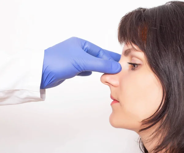 Lekarz chirurg plastyczny przygotowuje białą dziewczynę do operacji plastycznej nosa. Rhinoplastyka — Zdjęcie stockowe