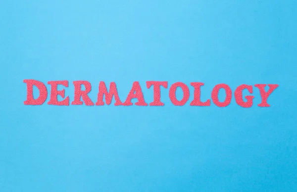 Mavi arka planda dermatoloji kelimesi. Tıbbın sorunlarla ilgilenen kavramsal bölümü ve baştaki deri ve saçların tedavisi — Stok fotoğraf