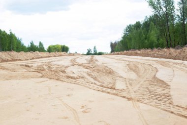 Geniş bir yol ve kaldırım inşaatı. Yeni bir patika, arkaplan, kopyalama alanı için kumda işaretleme