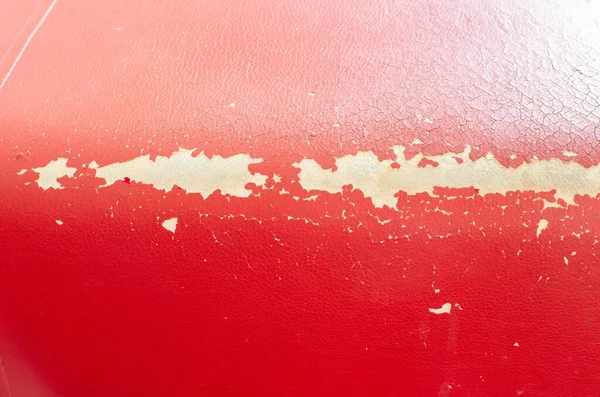 Textura de couro danificada nos estofos do sofá e móveis. Restauração e reparação, couro vermelho, fundo — Fotografia de Stock