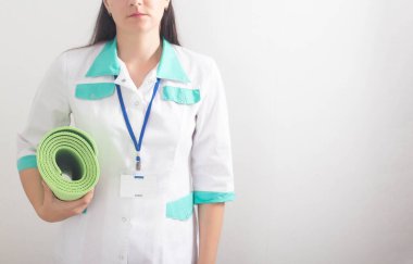 Beyaz arka planda spor paspası olan fizyoterapi egzersizleri yapan kadın doktor. Fiziksel egzersizlerle tedavi ve rehabilitasyon kavramı, boşluğu kopyala